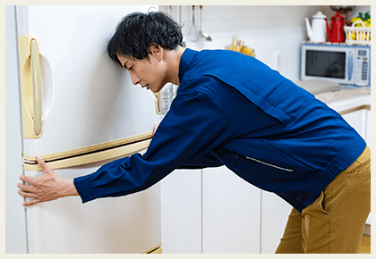 冷蔵庫を触る男性